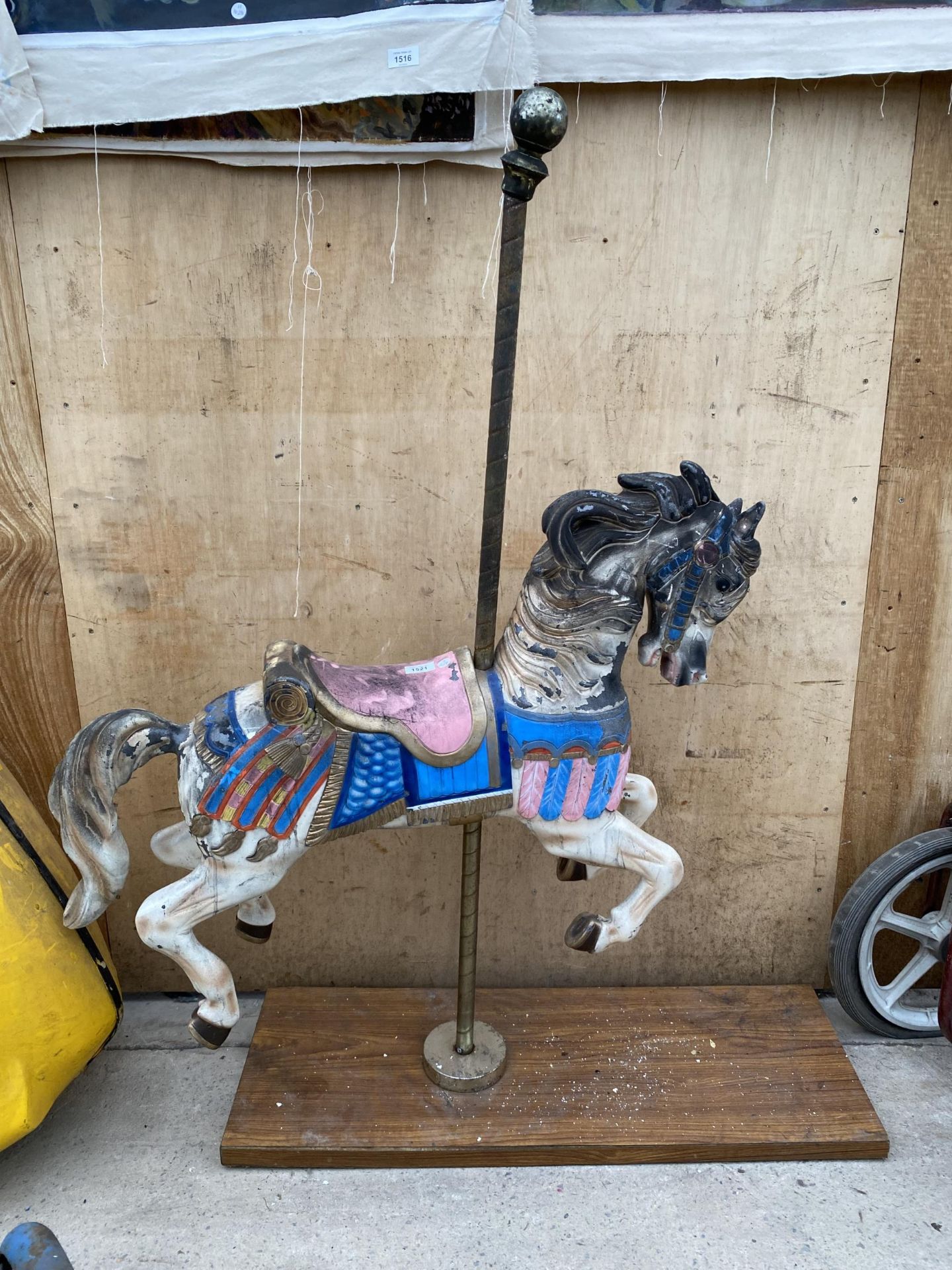 A VINTAGE CAROUSEL HORSE FAIRGROUND RIDE MOUNTED ON A WOODEN PLINTH