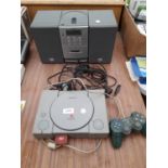 A PLAYSTATION ONE WITH CONTROLLER AND A SONY STEREO SYSTEM WITH TWO SPEAKERS