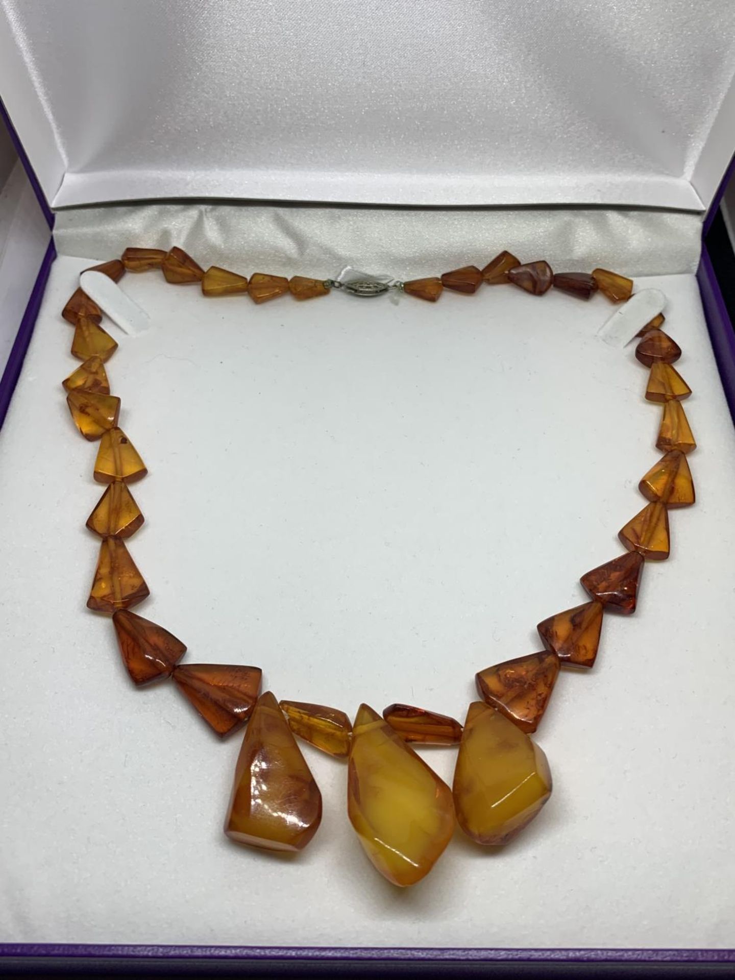 AN AMBER NECKLACE IN A PRESENTATION BOX