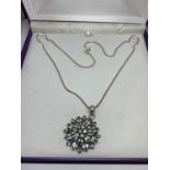 A SILVER NECKLACE WITH FLOWER DESIGN PENDANT IN A PRESENTATION BOX
