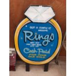 A WOODEN HAND PAINTED RING ADVERTISING SIGN