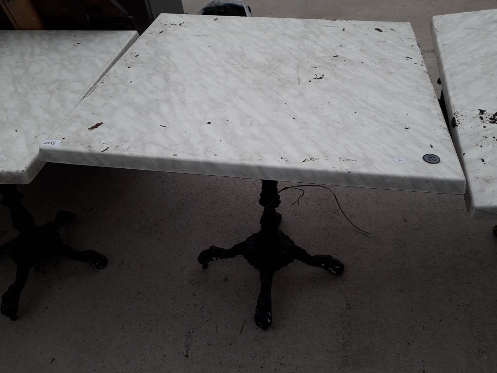 A PUB TABLE WITH WOODEN TOP AND CAST IRON TABLE BASE (79CM x 79CM)