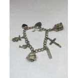 A SILVER BRACELET WITH SEVEN VARIOUS CHARMS