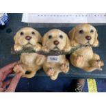 A RESIN COAT HANGER OF THREE GOLDEN LABRADOR PUPPIES