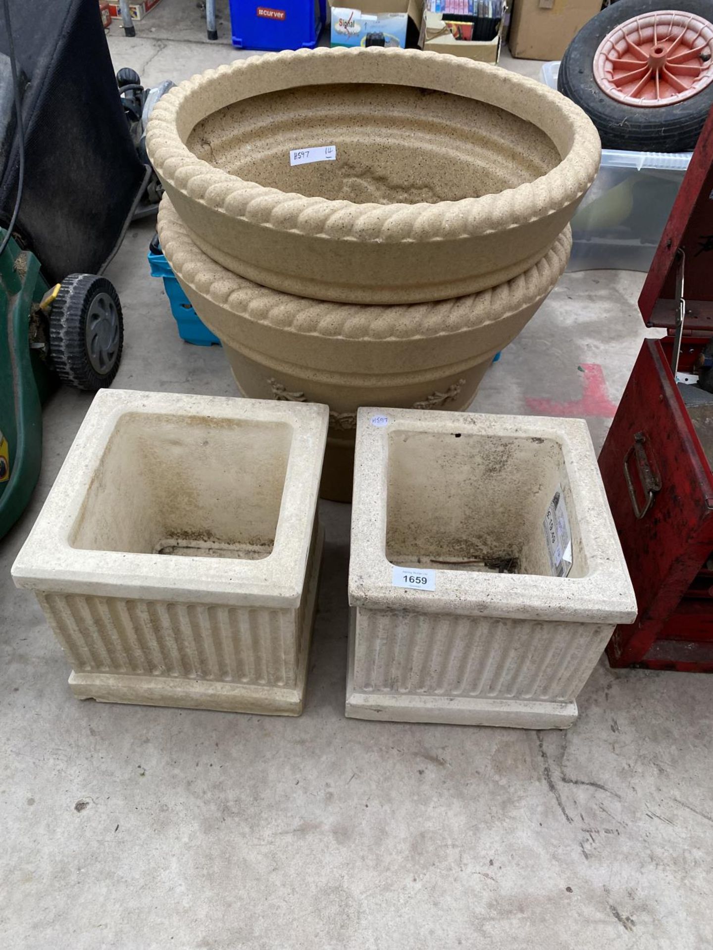 A PAIR OF SMALL RECONSTITUTED STONE PLANTERS AND A FURTHER PAIR OF ROUND PLASTIC PLANTERS
