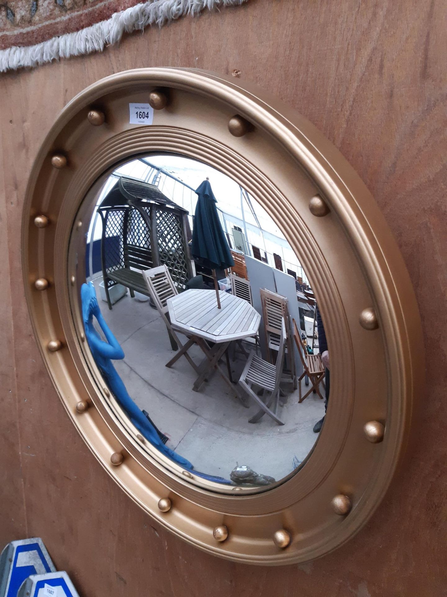 A WOODEN GILT FRAMED PORTHOLE STYLE MIRROR