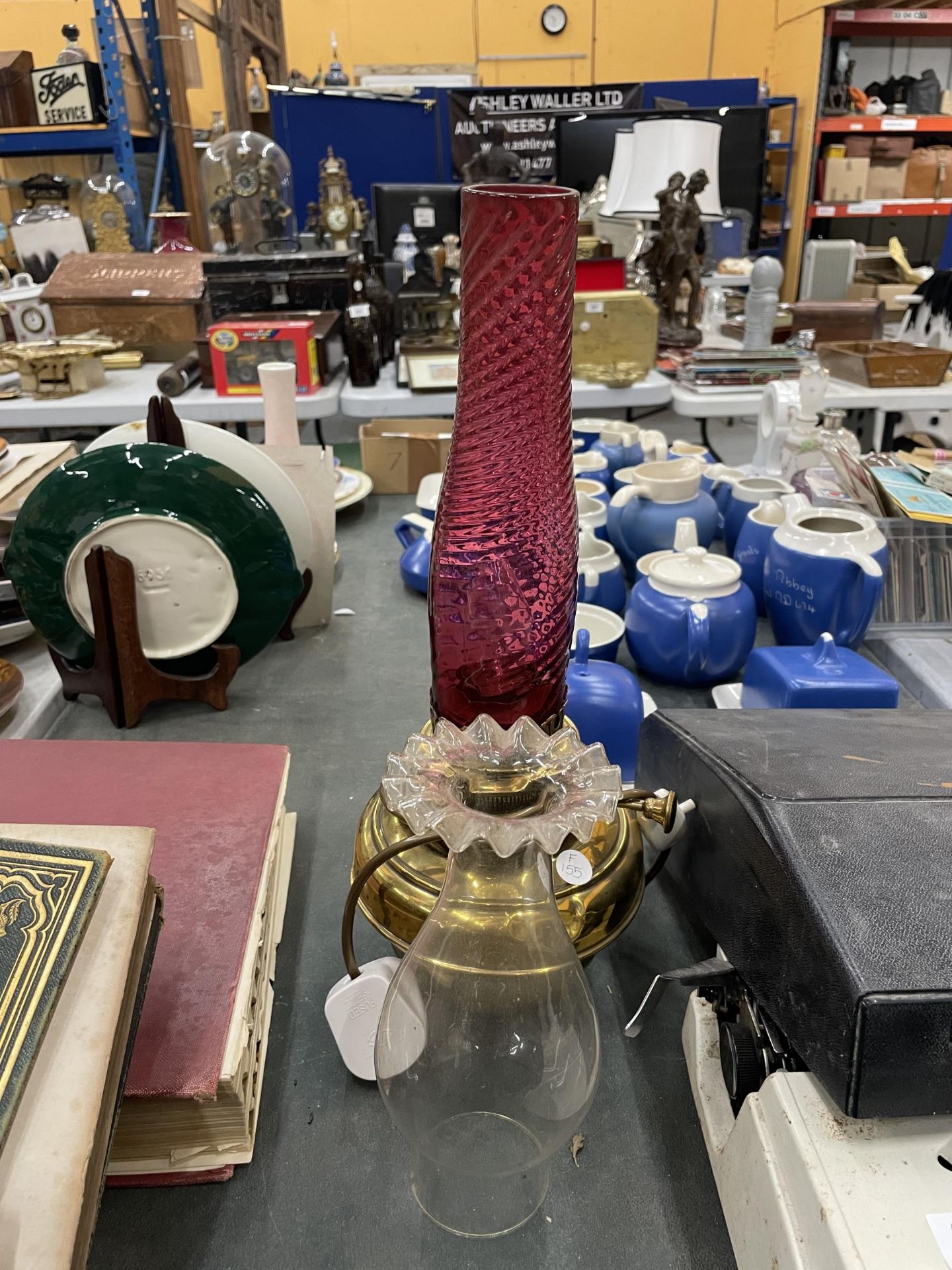 A BRASS OIL LAMP COVERTED TO ELECTRIC WITH TWO FUNNELS ONE CRANBERRY GLASS AND THE OTHER CLEAR GLASS