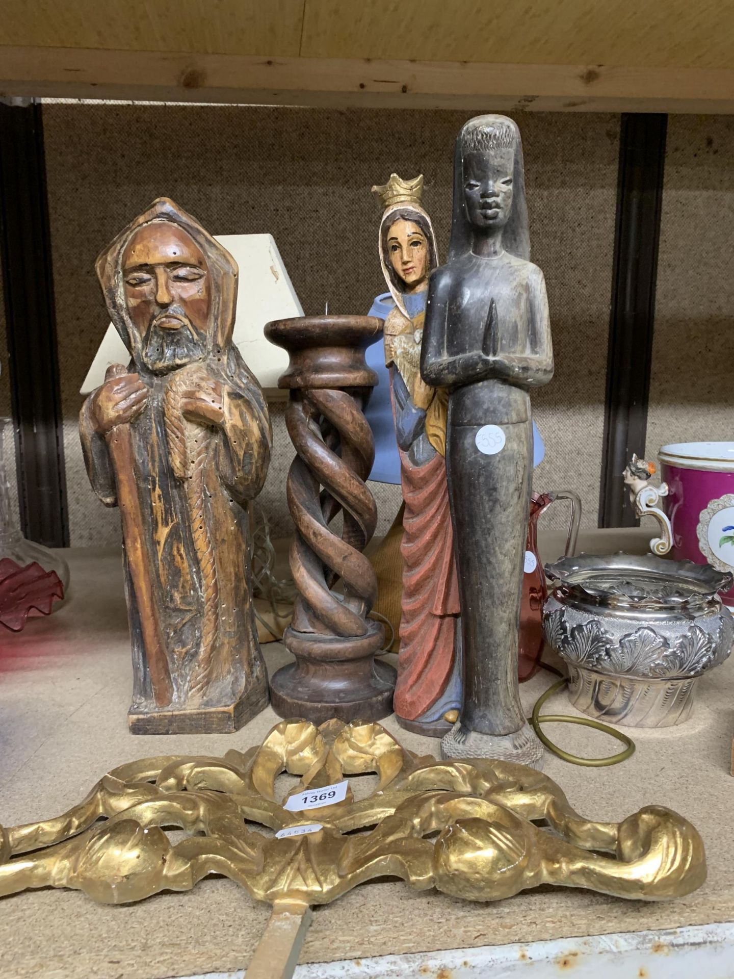A MIXED LOT TO INCLUDE RELIGIOUS CARVED FIGURES, A LARGE BARLEY TWIST WOODEN CANDLESTICK, TABLE