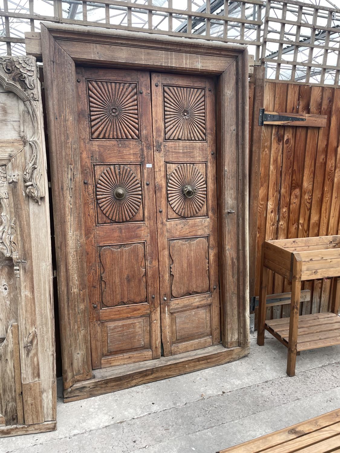 A PAIR OF INDIAN HARDWOOD DOORS WITH DECORATED PANELS + BRASS FITTINGS, 90 X 54" TO INCLUDE FRAME