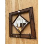 AN OAK FRAMED BEVELED EDGE HALL MIRROR COMPLETE WITH FIVE COAT HOOKS