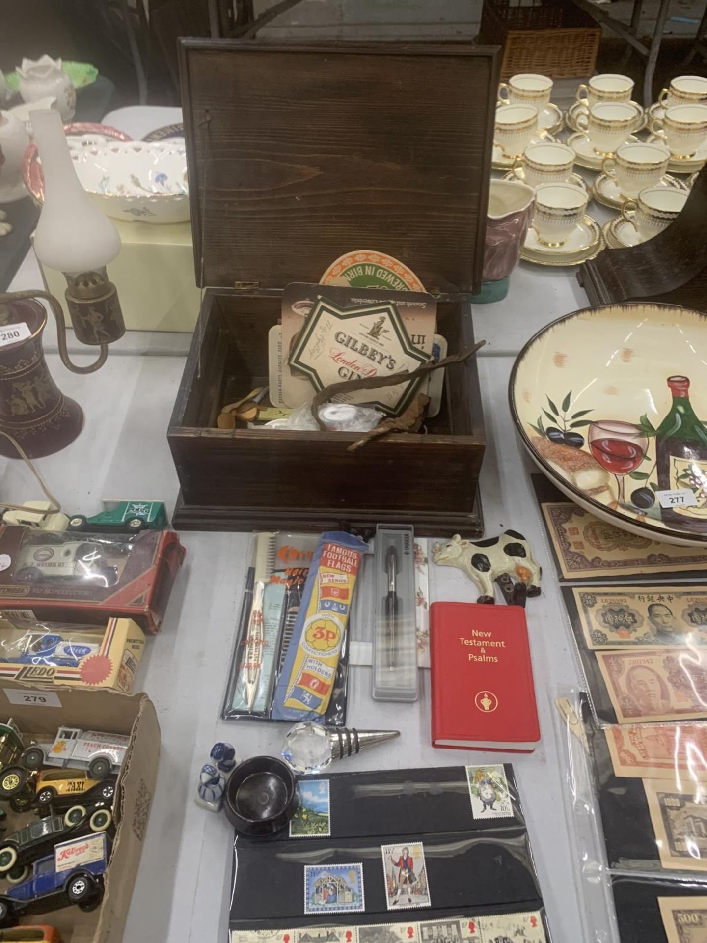 A WOODEN BOX CONTAINING VARIOUS ITEMS TO INCLUDE STAMPS, PENS, HOOKS, BEER MATS ETC