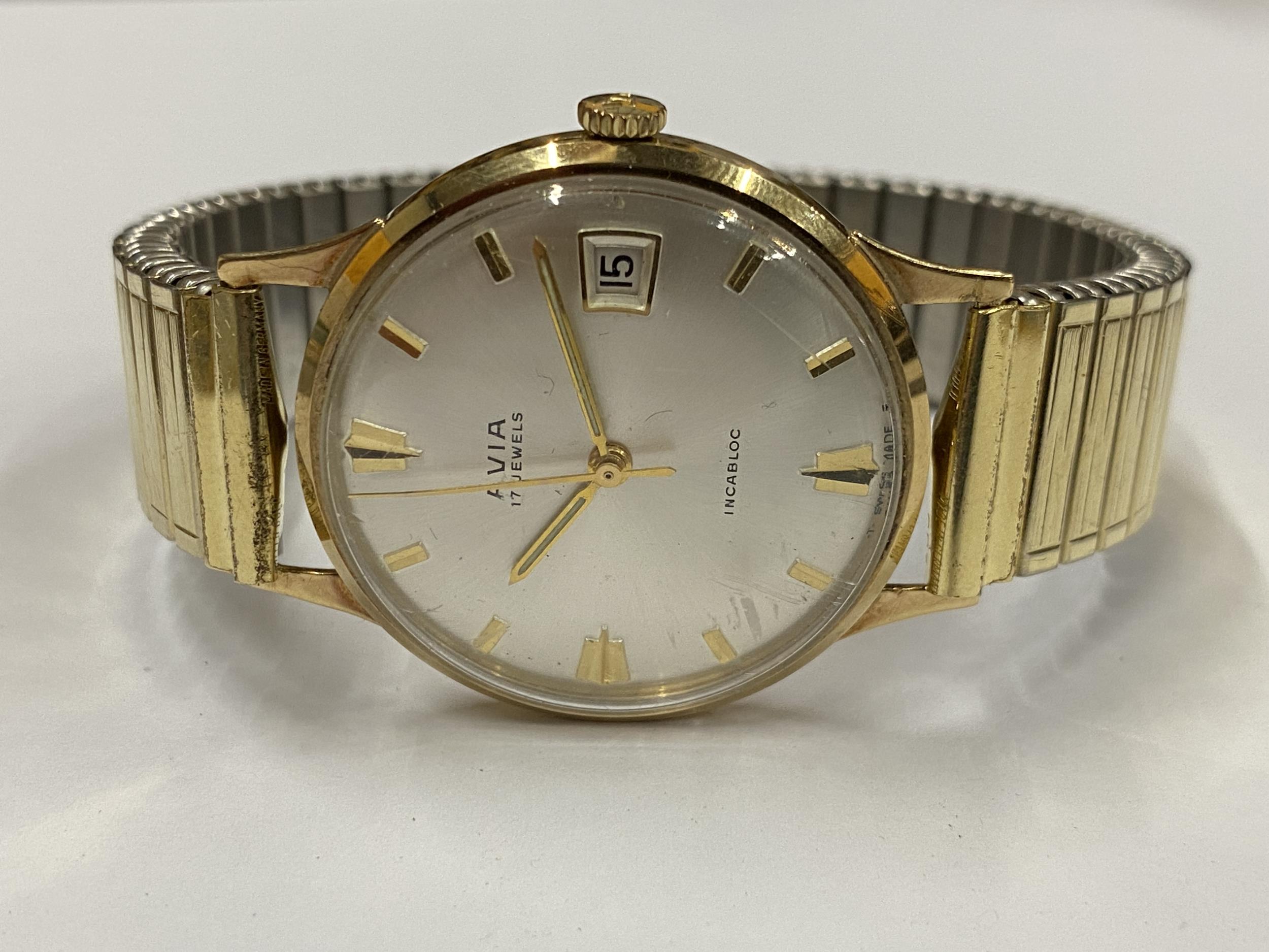 A GENTS 9CT GOLD CASED AVIA MANUAL WIND DATE WATCH WITH FLEXI STRAP IN ORIGINAL BOX