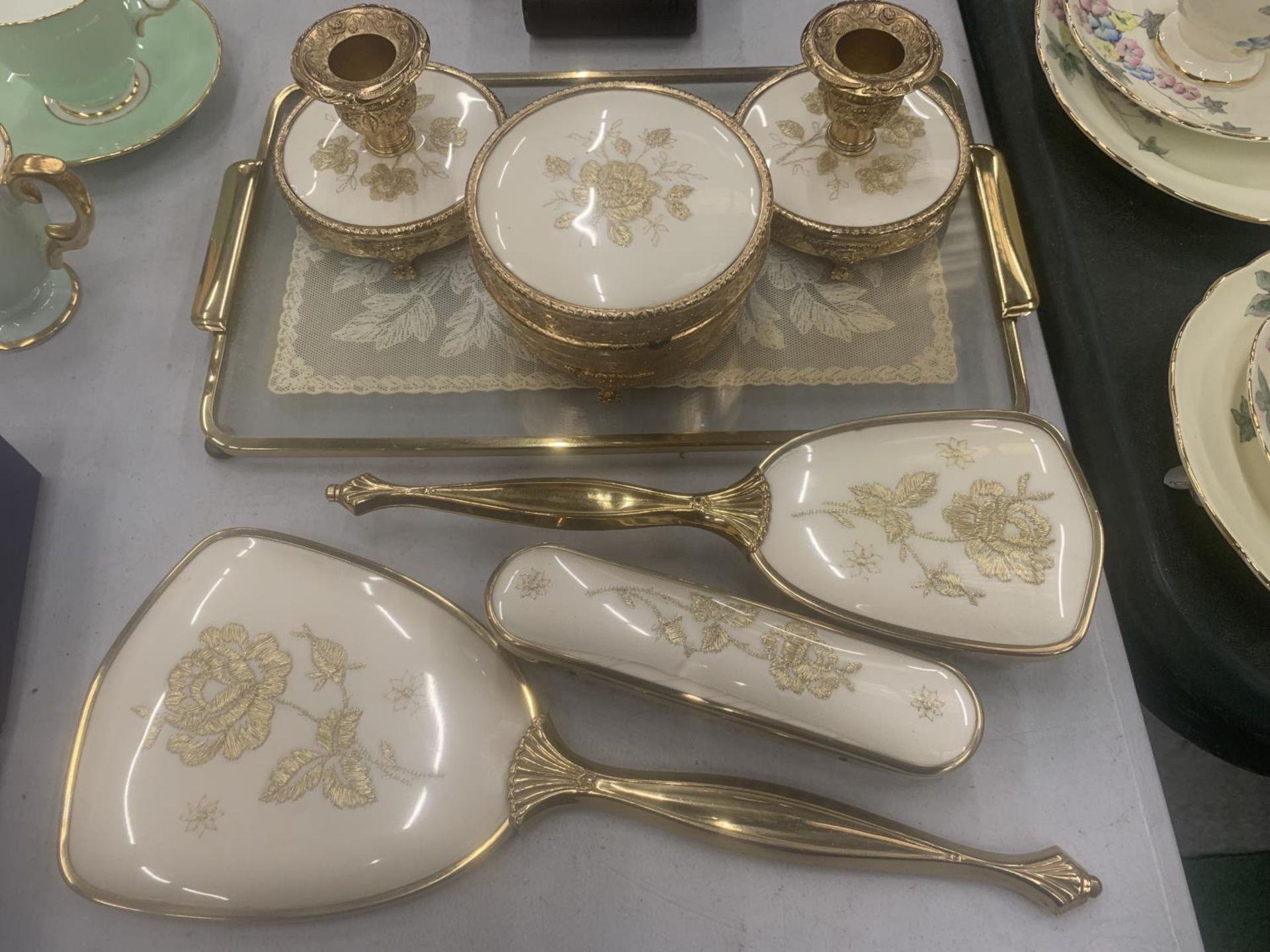 A VINTAGE DRESSING TABLE SET TO INCLUDE A GLASS TRAY, CANDLESTICKS, TRINKET BOX, BRUSHES AND HAND