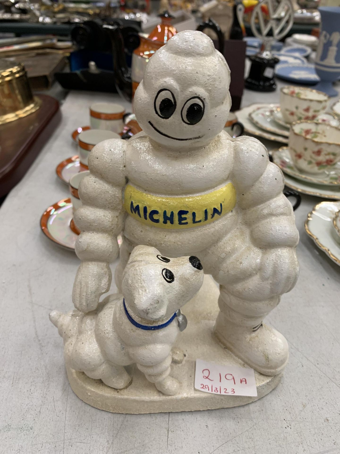 A CAST MODEL OF A MICHELIN MAN AND DOG HEIGHT 20CM