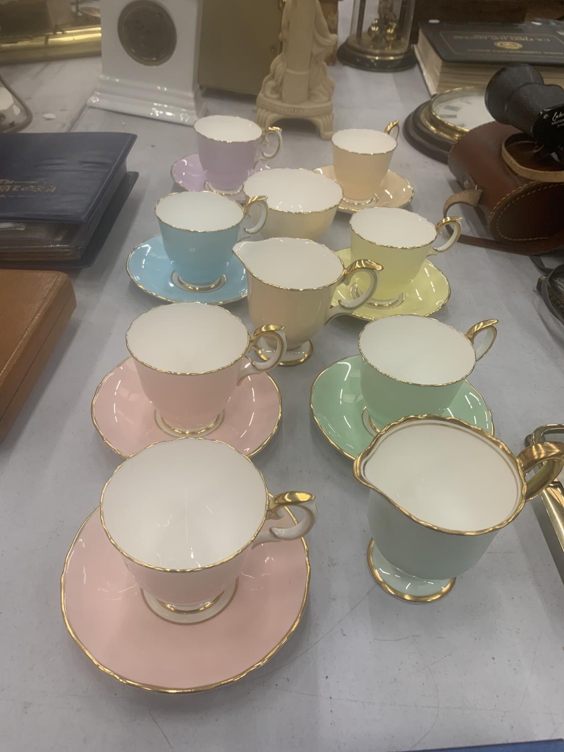 A QUANTITY OF CROWN STAFFORDSHIRE 'HARLEQUIN' CUPS, SAUCERS, CREAM JUGS AND SUGAR BOWL
