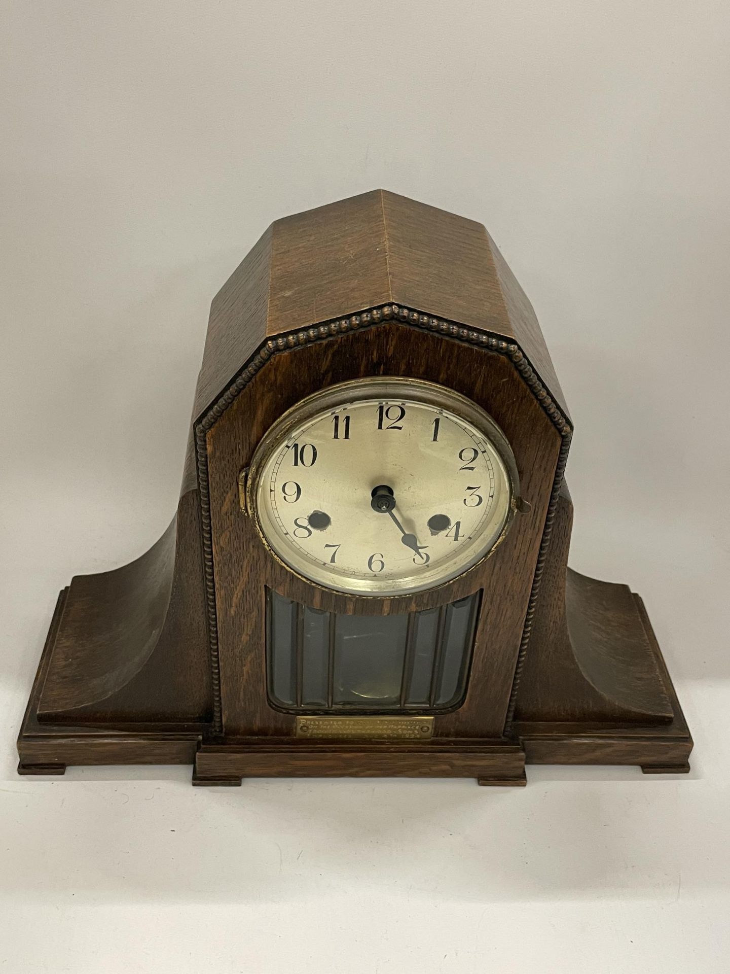 AN EARLY 20TH CENTURY OAK CHIMING MANTLE CLOCK WITH PRESENTATION PLAQUE DATED 1924