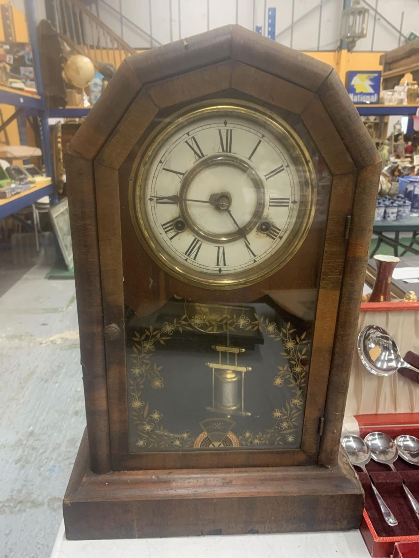 A VINTAGE MAHOGANY CASED MANTLE CLOCK WITH FLORAL DECORATED GLASS DOOR, TO INCLUDE PENDULUM AND