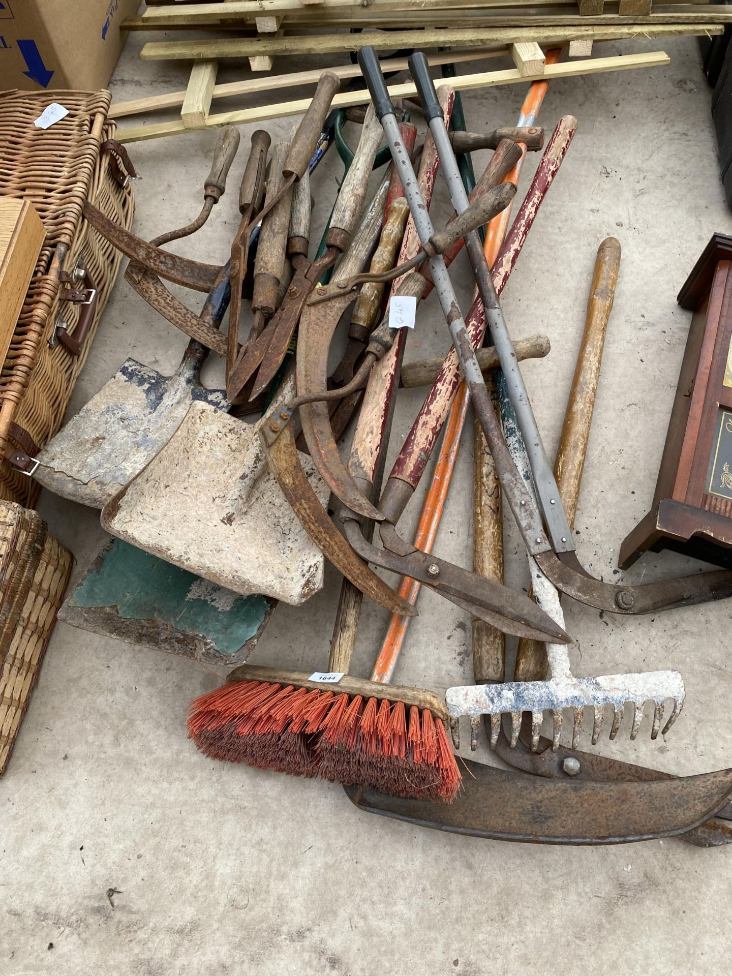 A LARGE ASSORTMENT OF GARDEN TOOLS TO INCLUDE SYTHES AND SHEARS ETC