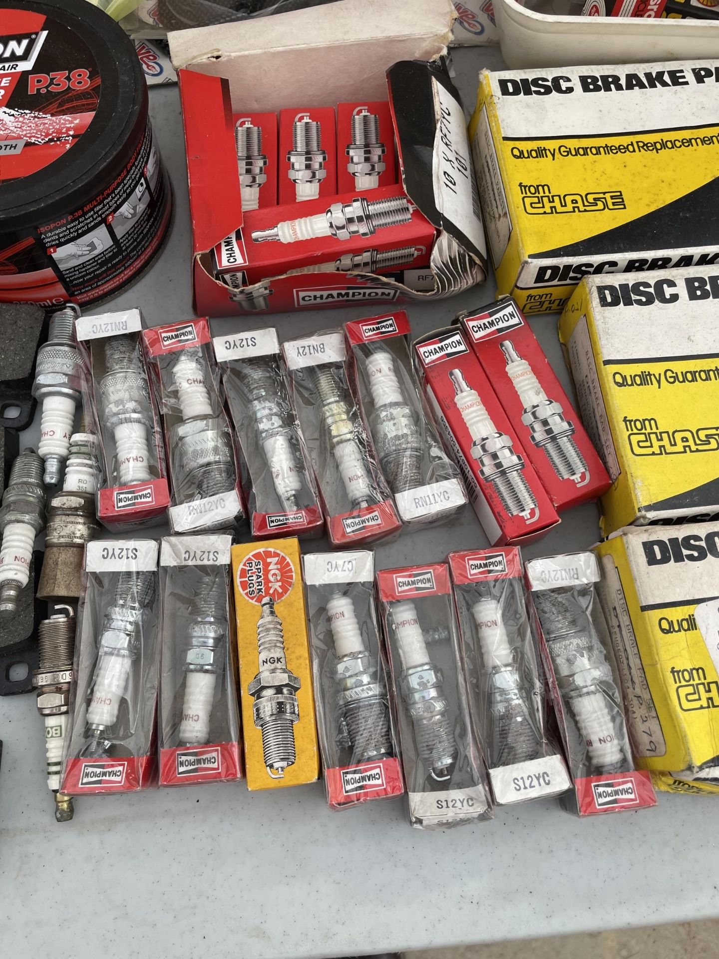 A COLLECTION OF VINTAGE AUTOMOBILE PARTS TO INCLUDE SPARK PLUGS, BRAKE PADS, ETC - Image 2 of 3