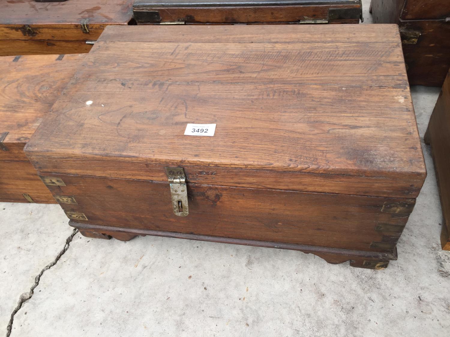 AN INDIAN HARDWOOD BOX WITH BRASS STRAPS, 19" WIDE