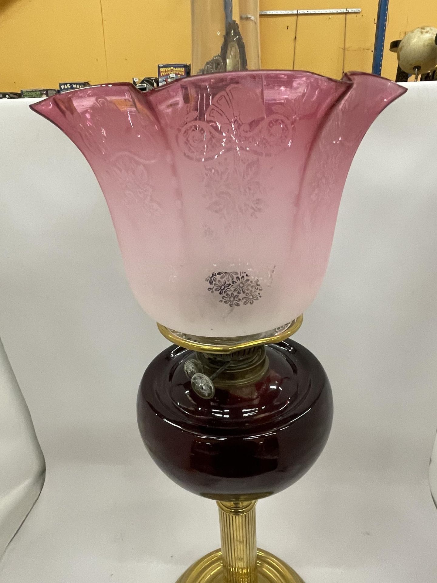 AN EARLY TO MID 20TH CENTURY BRASS CORINTHIAN COLUMN OIL LAMP WITH CRANBERRY GLASS SHADE - Bild 2 aus 3