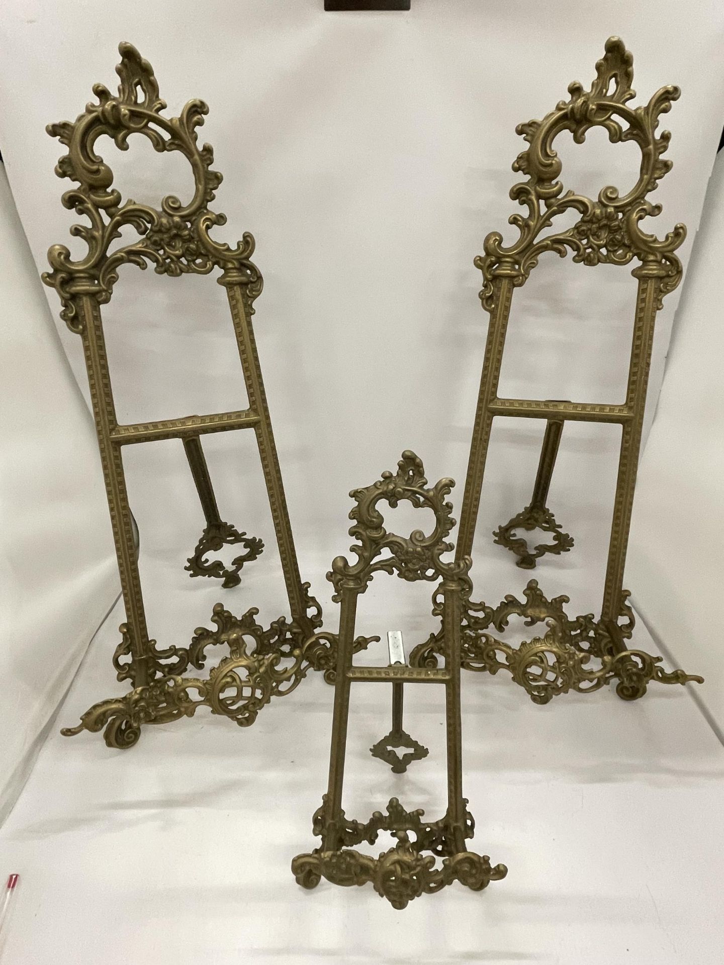 THREE ORNATE VINTAGE BRASS TABLE TOP EASEL DISPLAYS, HEIGHT OF LARGE PAIR 53CM