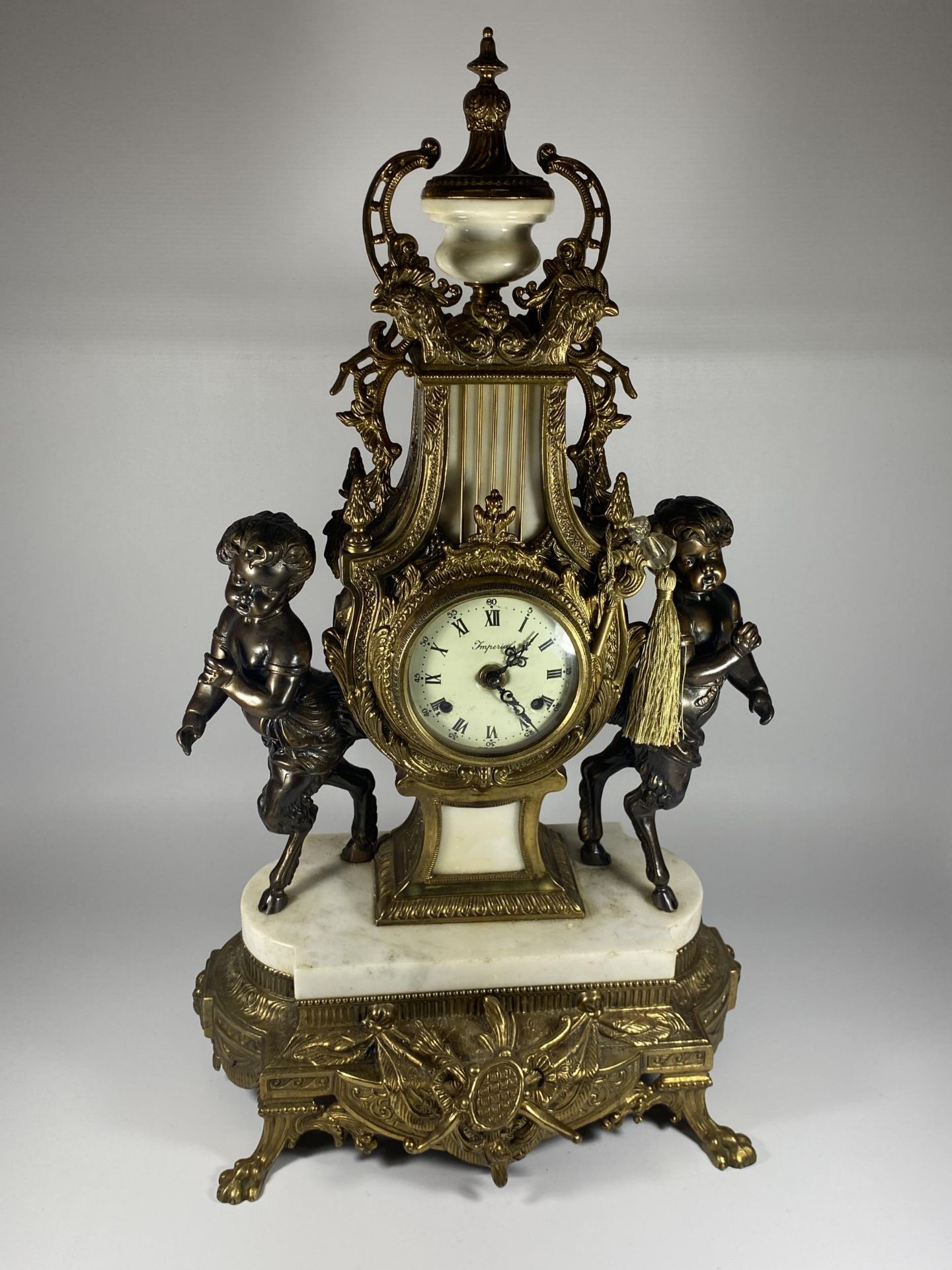 A C.1900 ITALIAN REPRODUCTION MANTLE CLOCK BY IMPERIAL IN BRASS WITH MARBLE BASE AND CHERUBS, HEIGHT