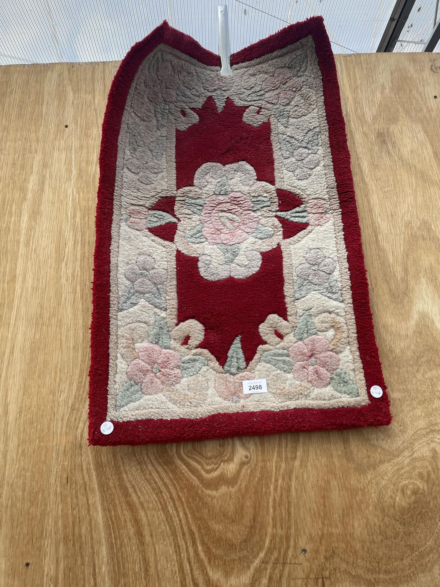 A SMALL RED PATTERNED RUG