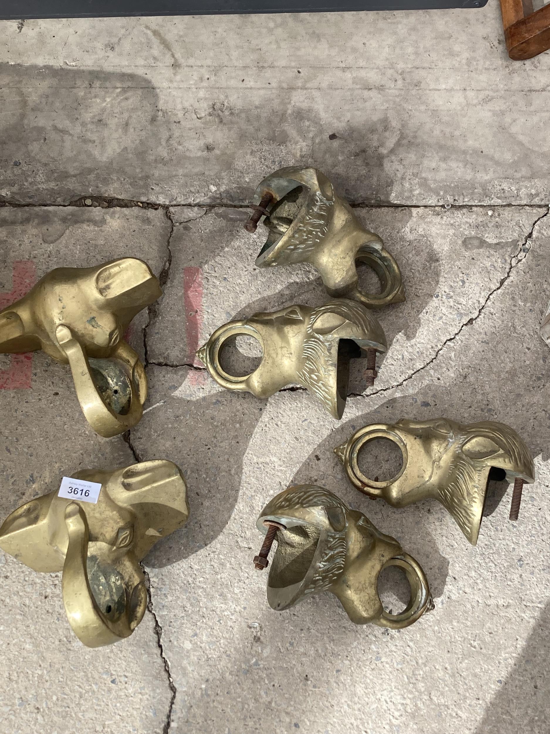 A GROUP OF BRASS ANIMAL CURTAIN POLL HOLDERS