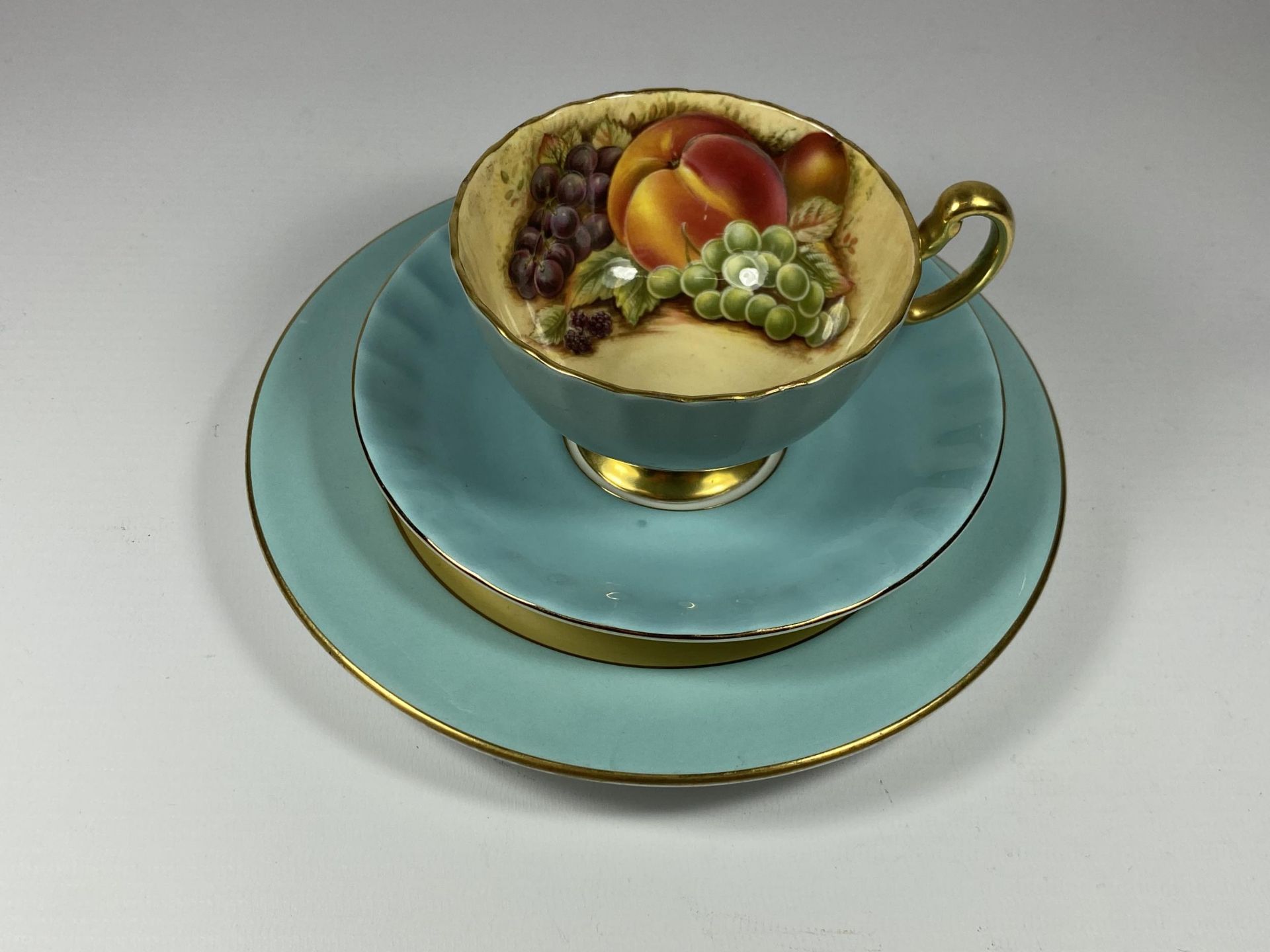 AN AYNSLEY CUP SAUCER AND SIDE PLATE TRIO