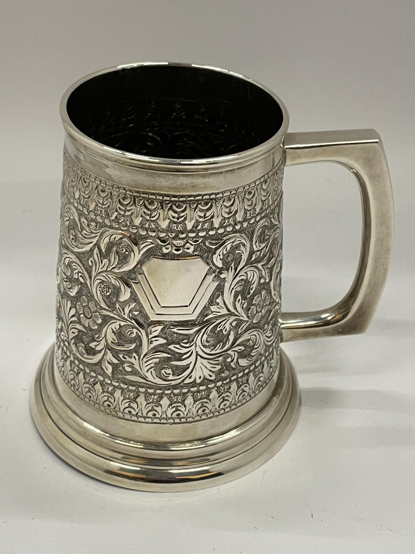 A STERLING SILVER TANKARD WITH FOLIATE CHASED AND ENGRAVED DESIGN WITH VACANT CARTOUCHE, STAMPED