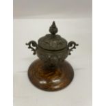 A TWIN HANDLED BRONZE LIDDED INKWELL ON OAK BASE