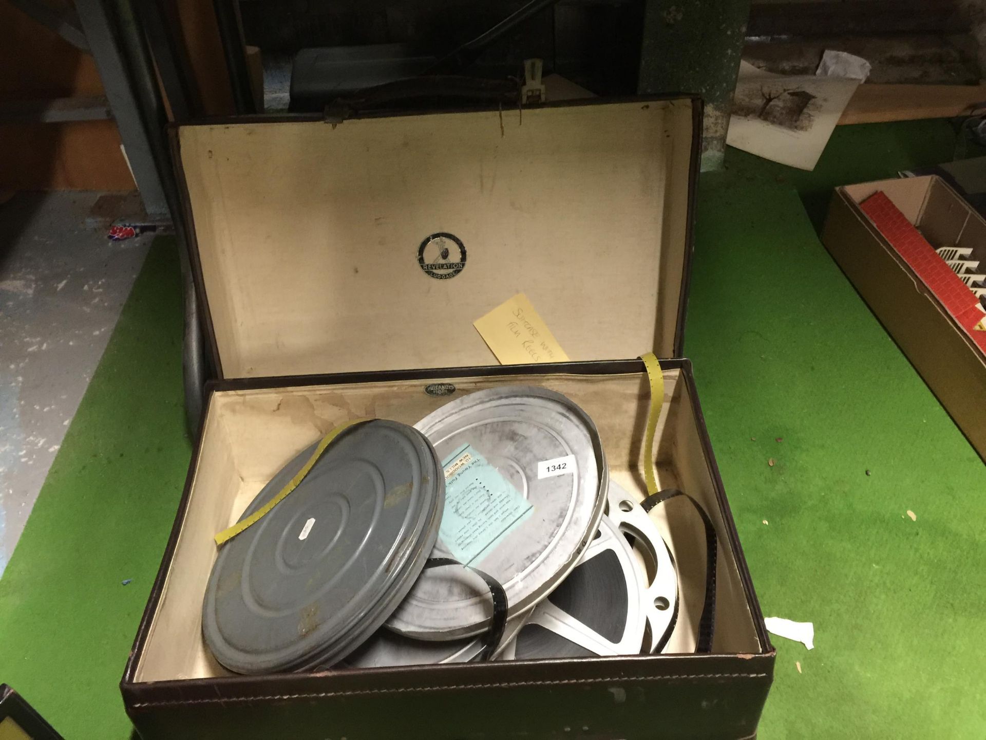 A VINTAGE 'REVELATION' SUITCASE CONTAINING A QUANTITY OF FILM REELS