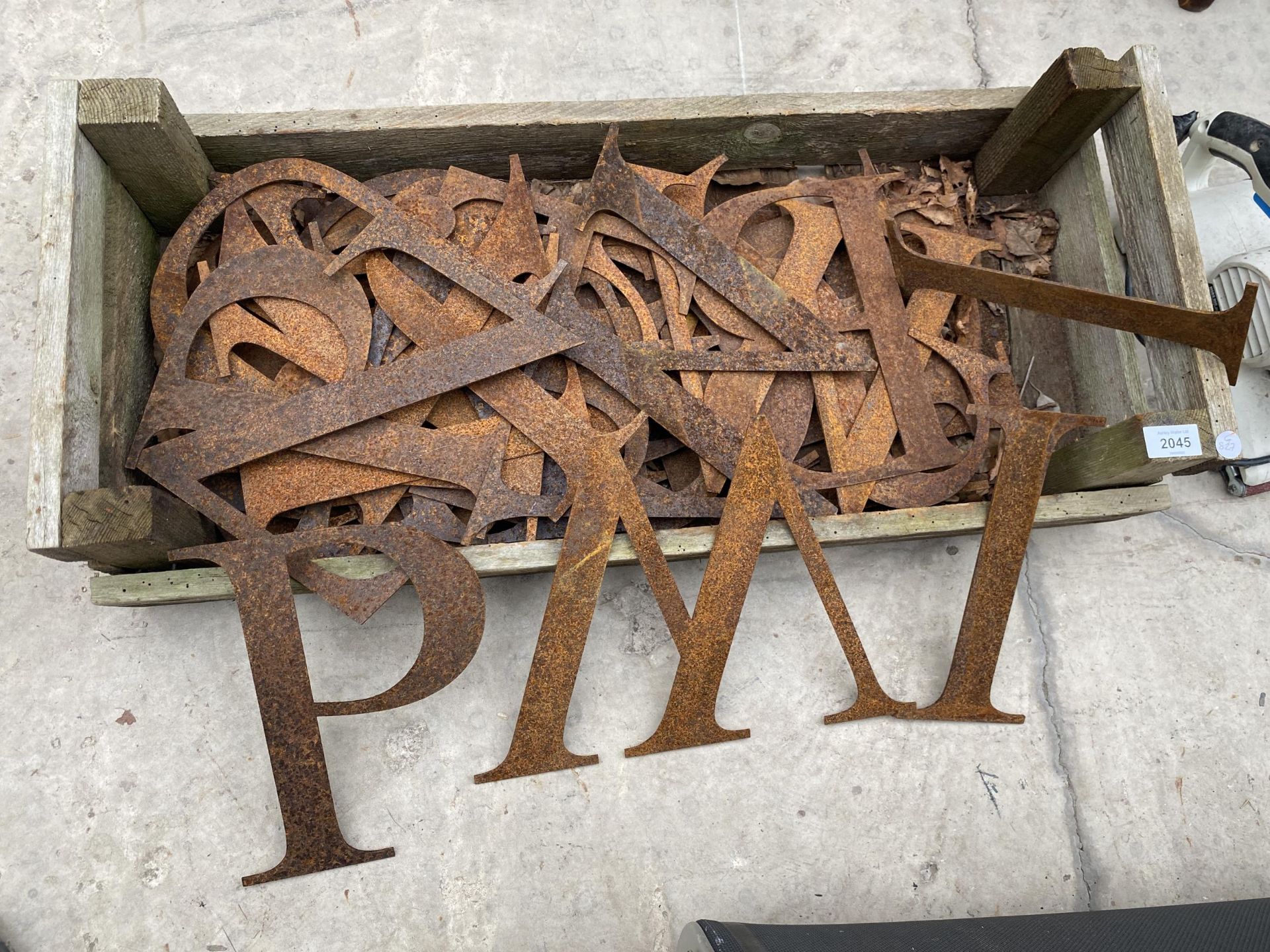 A WOODEN TRAY OF VINTAGE METAL LETTERS