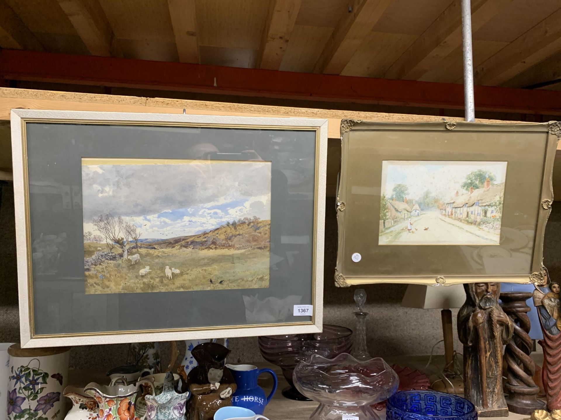 TWO FRAMED WATERCOLOURS, ONE OF SHEEP IN A FIELD THE OTHER A VILLAGE SCENE