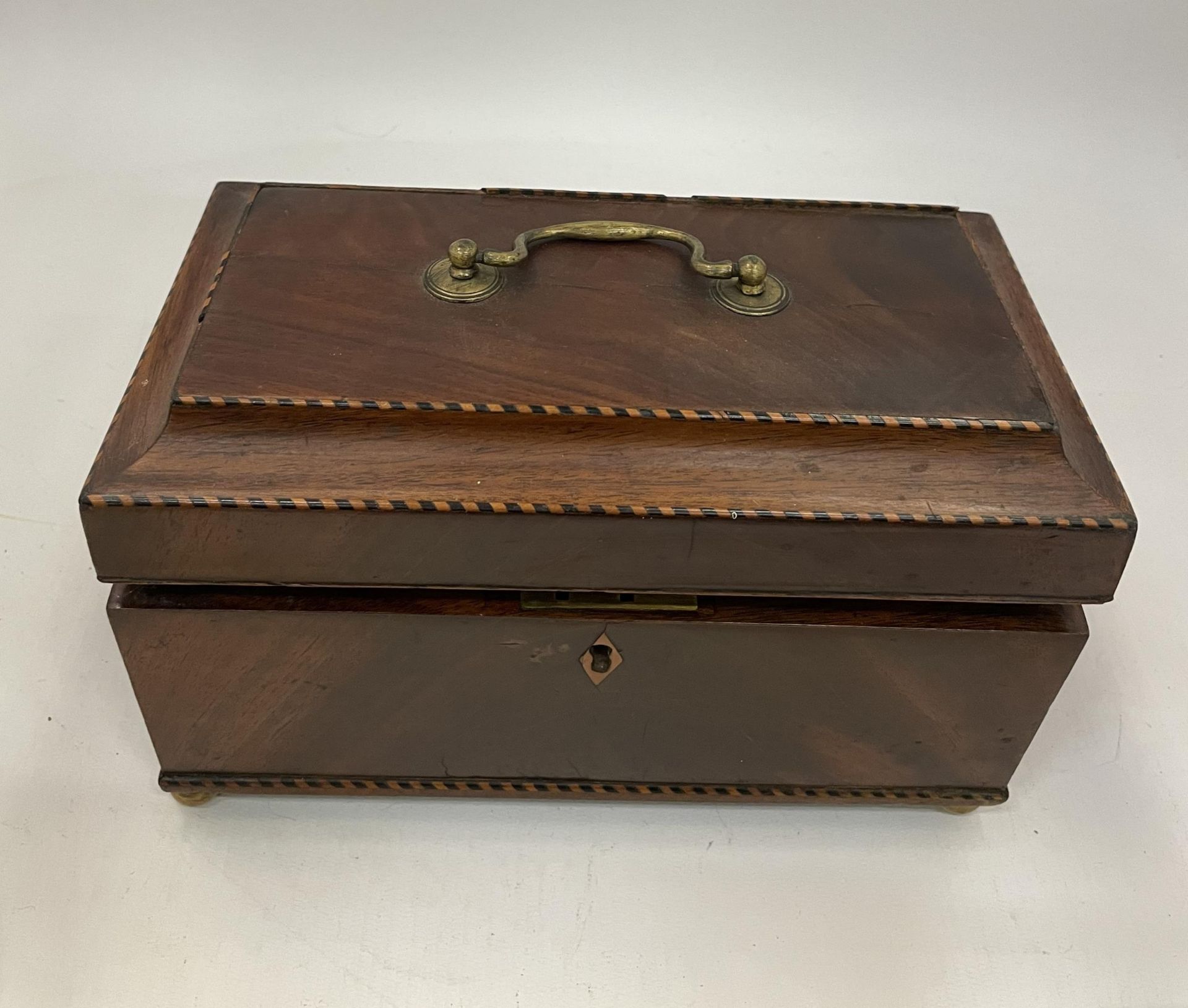 AN EDWARDIAN INLAID MAHOGANY JEWELLERY BOX WITH BRASS HANDLE AND INNER PULL OUT FELT LINED TRAY