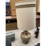 A LARGE DECORATIVE GILT COLOURED CERAMIC TABLE LAMP WITH LARGE CREAM SHADE