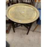 A MIDDLE EASTERN BRASS TABLE, 23.5" DIAMETER, ON FOLDING BASE