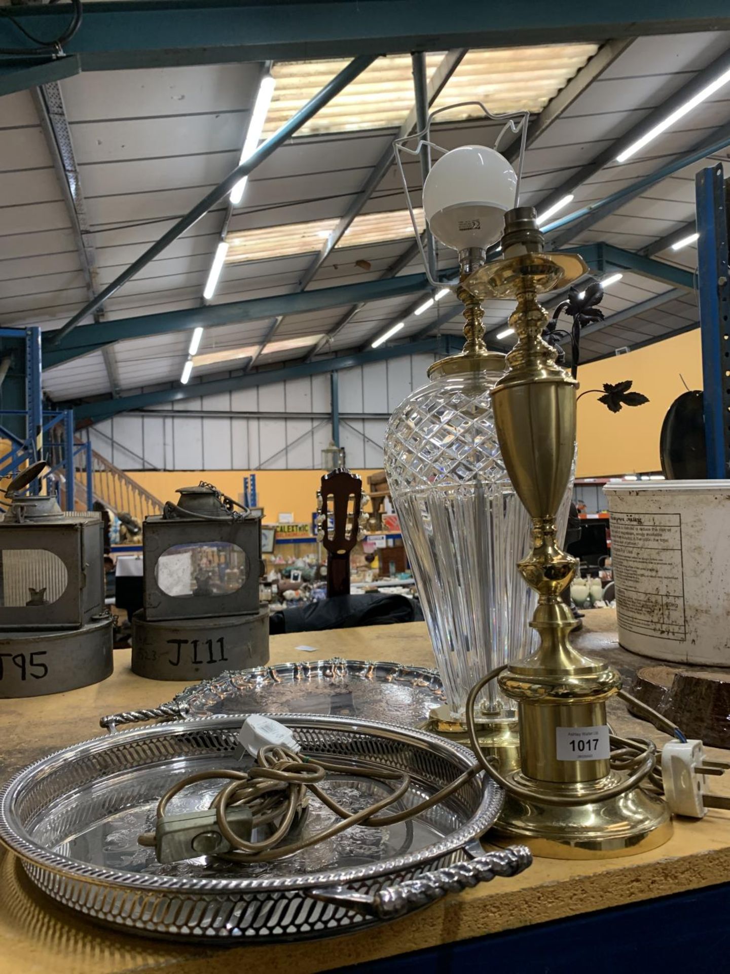 A LARGE CRYSTAL LAMP BASE TOGETHER WITH A BRASS LAMP BASE AND TWO SILVER PLATE TRAYS