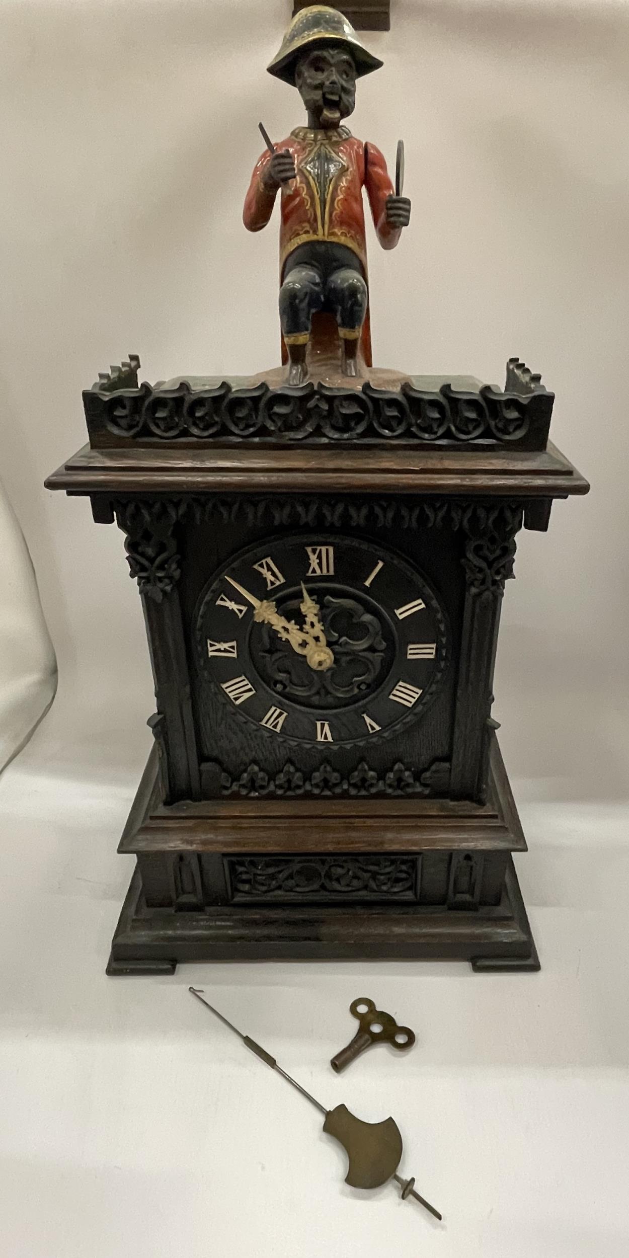 AN EARLY 20TH CENTURY NOVELTY AUTOMATION CARVED DARK OAK MANTLE CLOCK WITH NAPOLEONIC MONKEY
