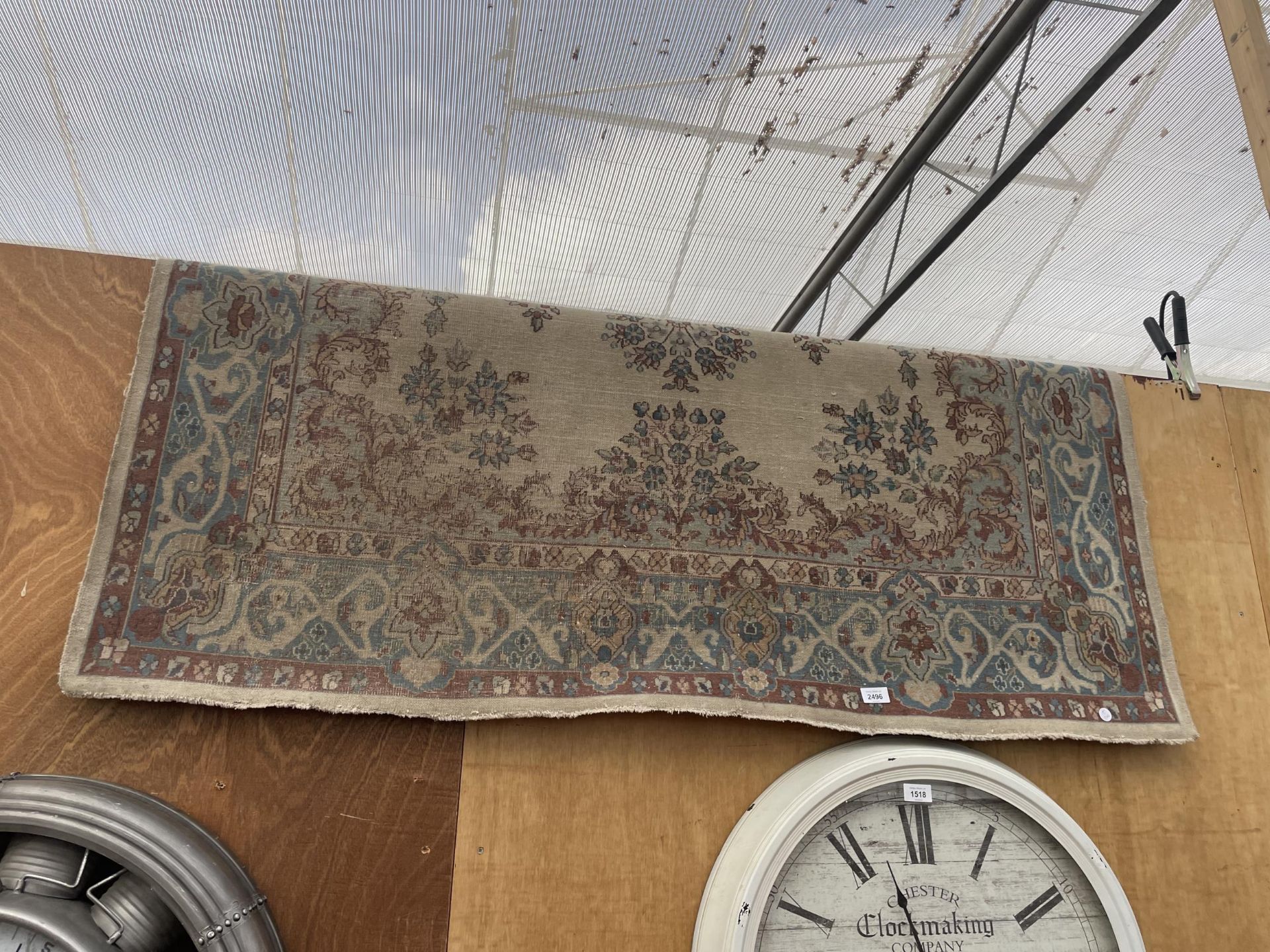 A VINTAGE RED PATTERNED FRINGED RUG