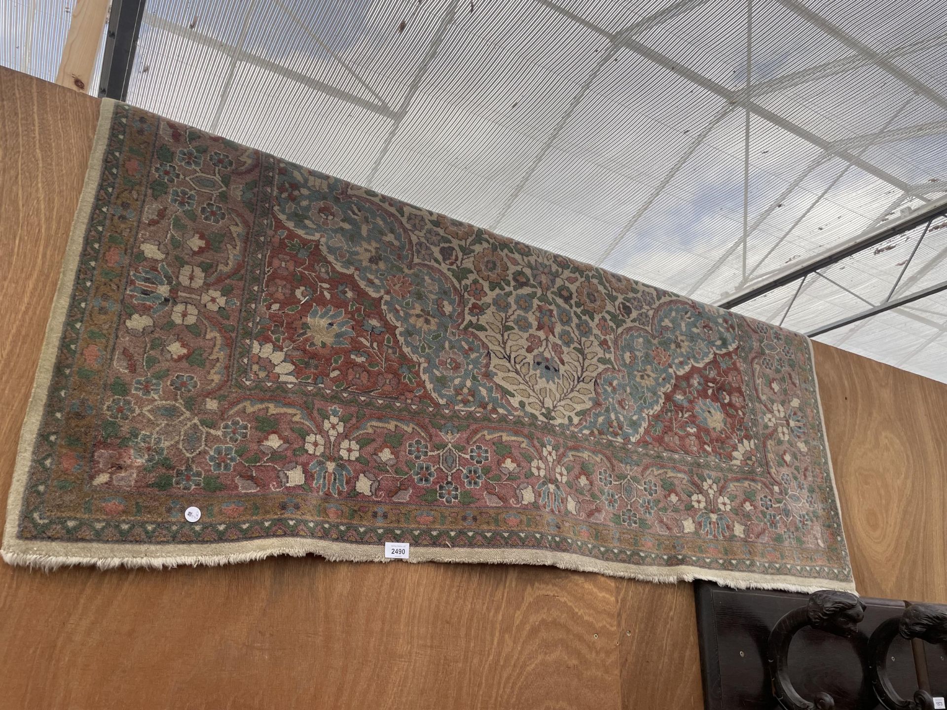 A VINTAGE RED PATTERNED FRINGED RUG