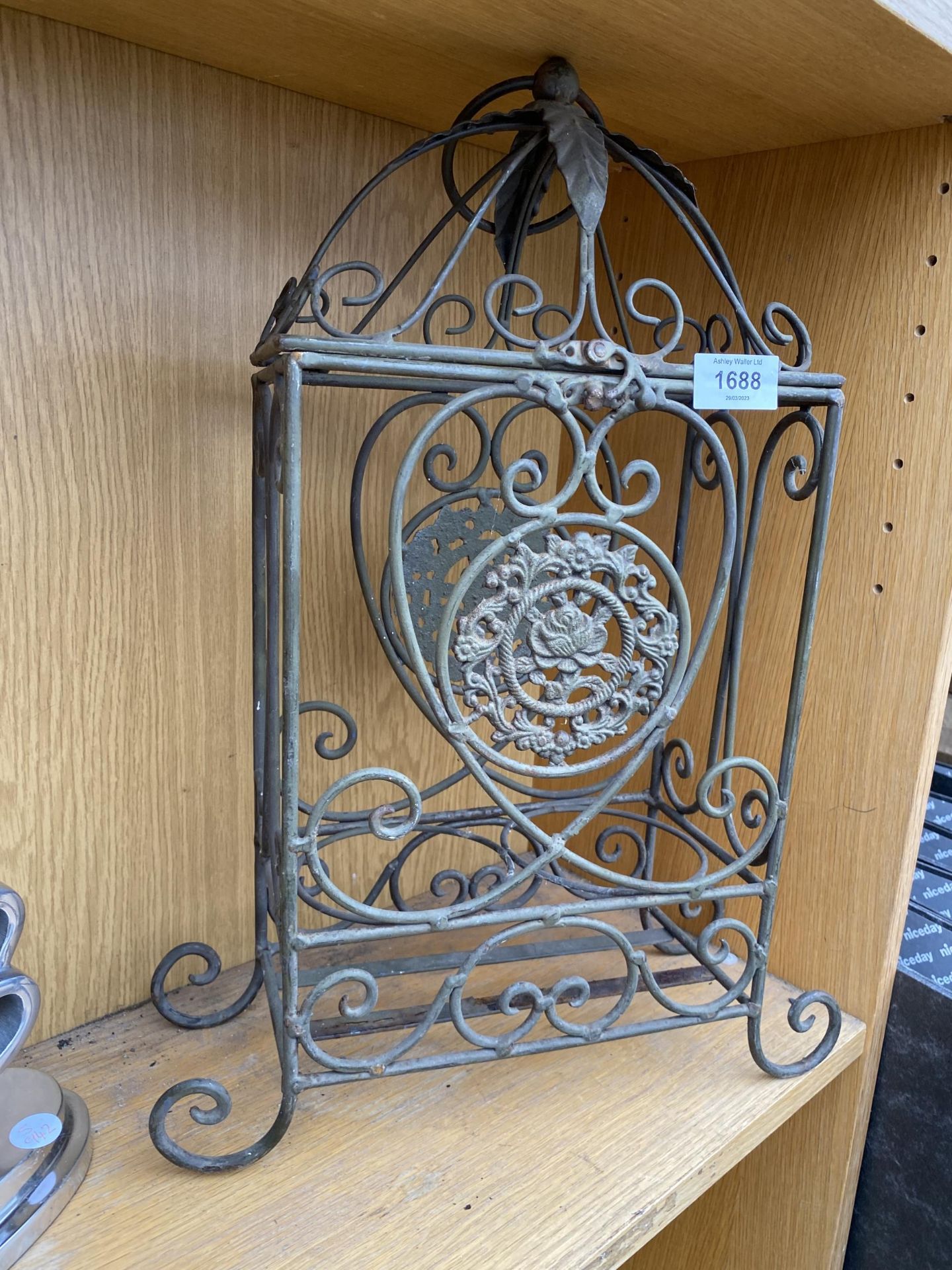 AN ORNATE WROUGHT IRON TWO SECTION WINE BOTTLE HOLDER WITH HINGED LID