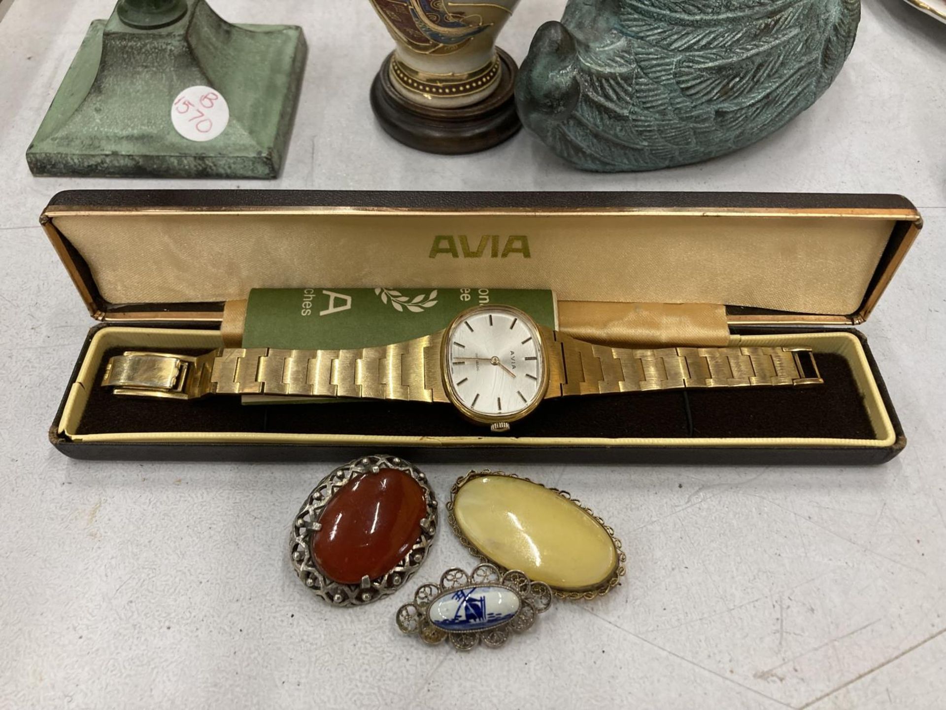 AN AVIA WRISTWATCH BOXED PLUS THREE BROOCHES, TWO WITH STONES