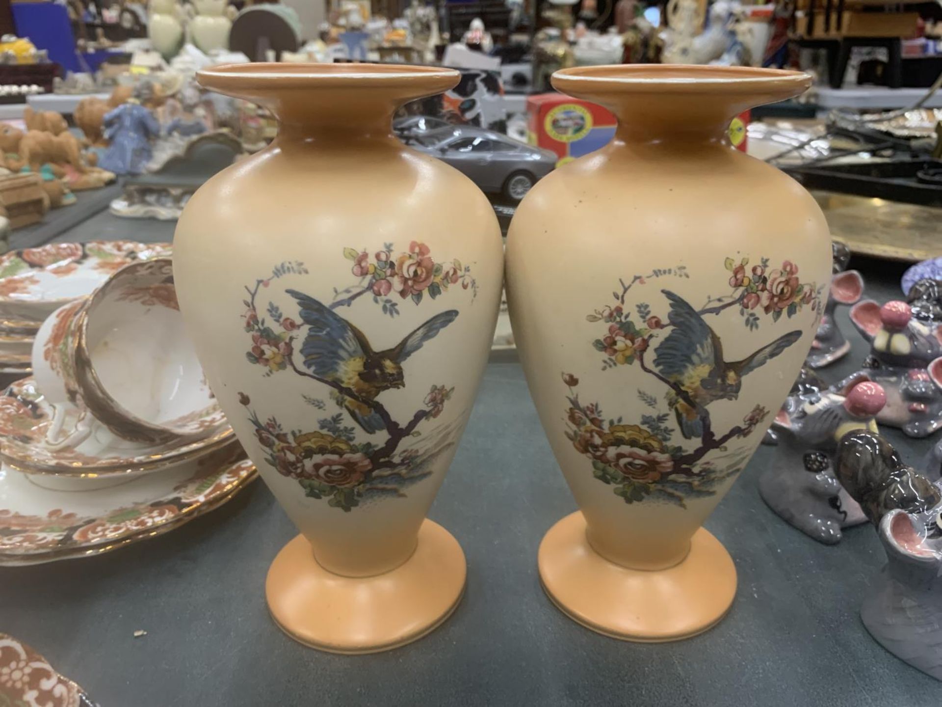 A PAIR OF VINTAGE PEACH BLUSH VASES WITH BIRD DECORATION HEIGHT 20CM