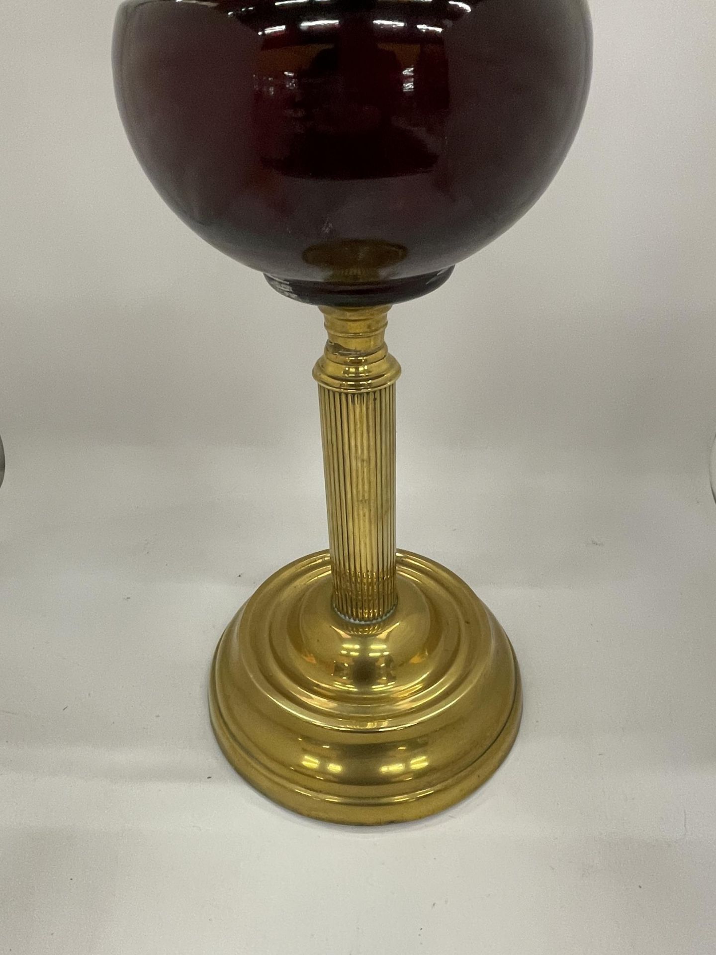 AN EARLY TO MID 20TH CENTURY BRASS CORINTHIAN COLUMN OIL LAMP WITH CRANBERRY GLASS SHADE - Bild 3 aus 3