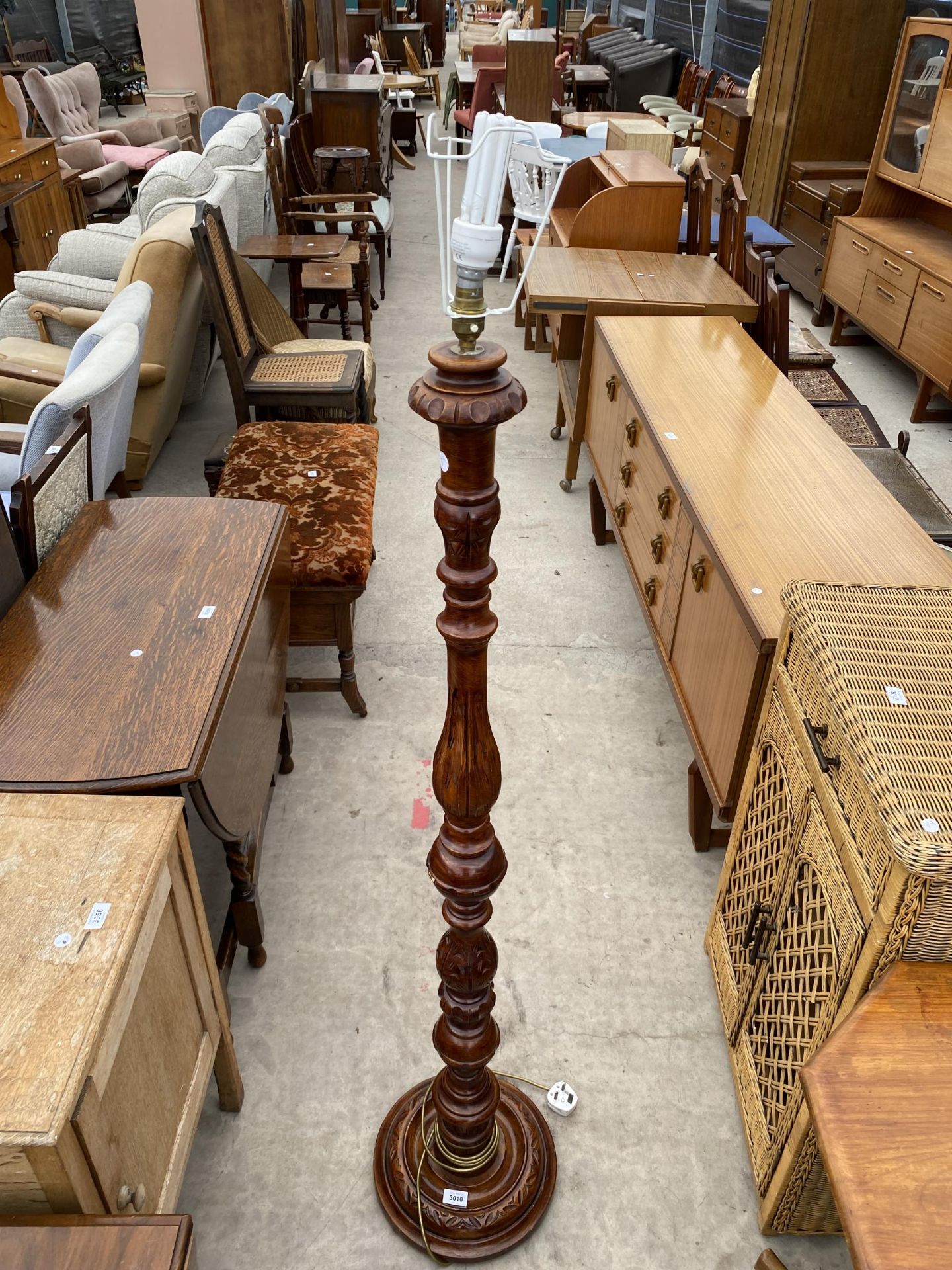 A HARDWOOD STANDARD LAMP ON TURNED COLUMN