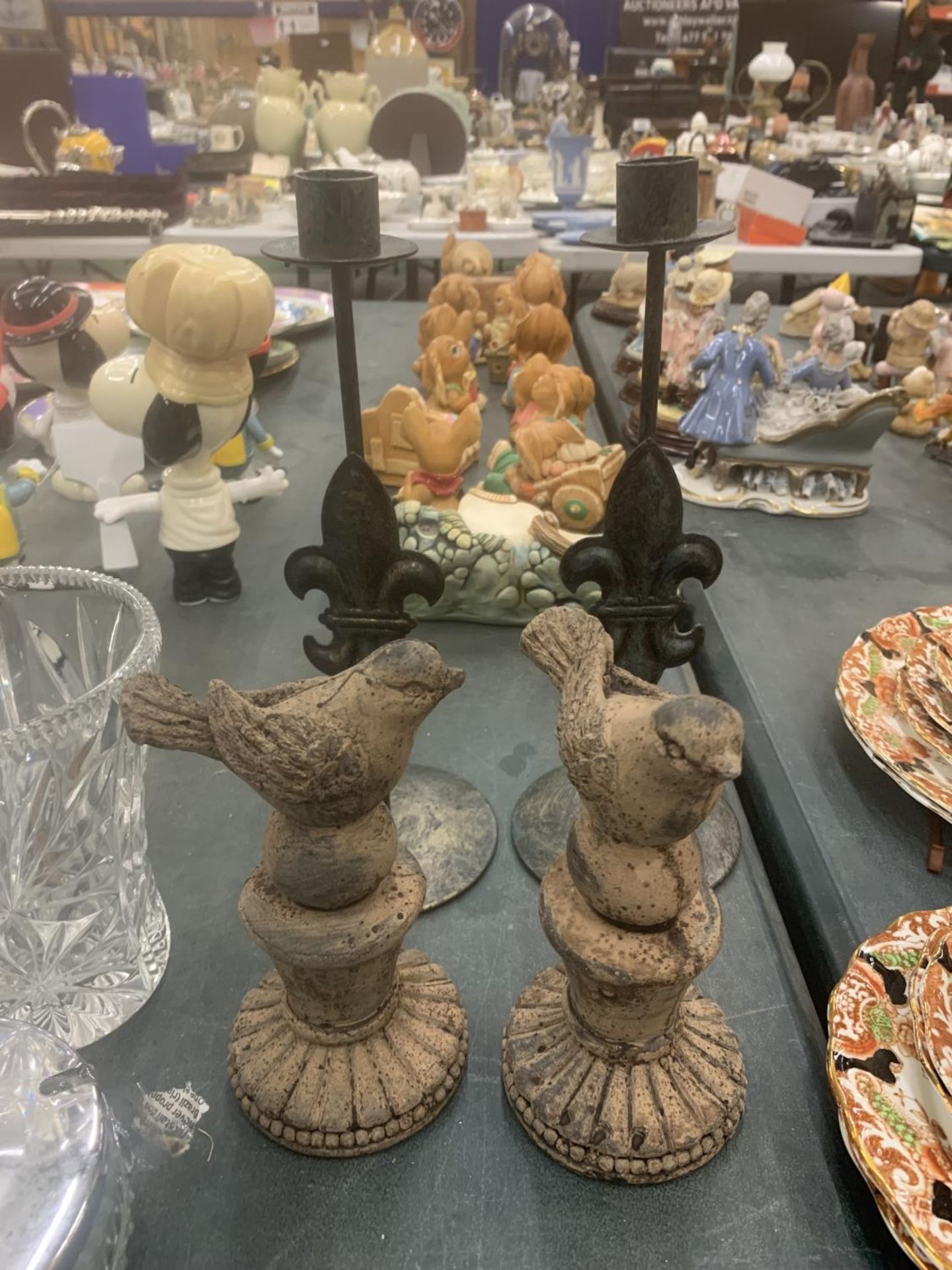 A PAIR OF METAL CANDLESTICKS WITH FLEUR-DU-LYS DECORATION AND A PAIR OF STONE BIRD FIGURES