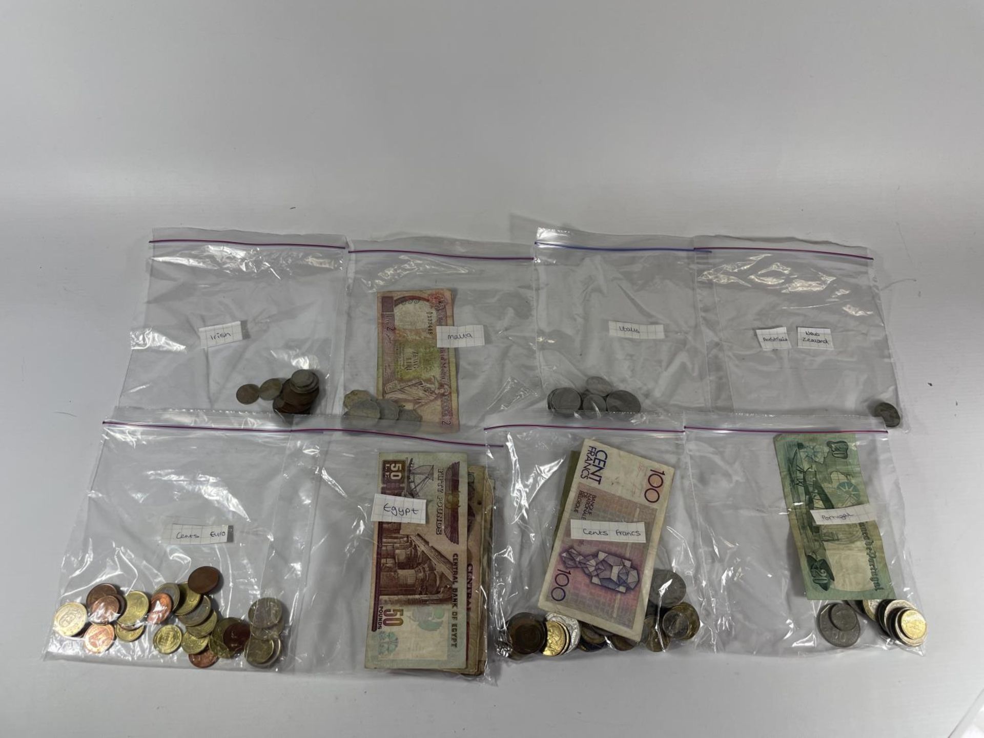 A QUANTITY OF COINS AND NOTES FROM AROUND THE WORLD TO INCLUDE NEW ZEALAND, MALTA, IRELAND ETC