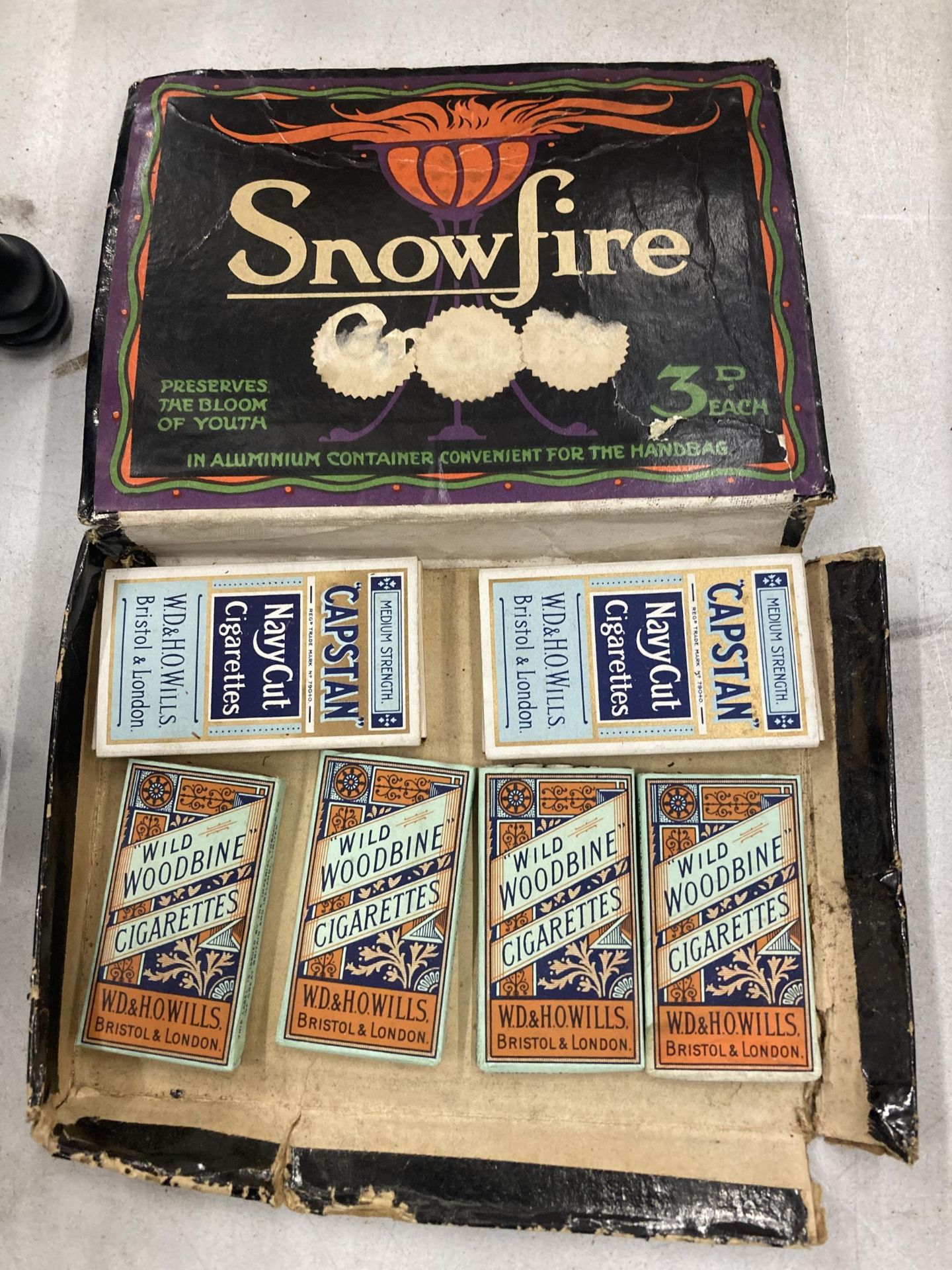 A VINTAGE 'SNOWFIRE' BOX CONTAINING CAPSTAN AND WOODBINE CIGARETTES IN BOXES